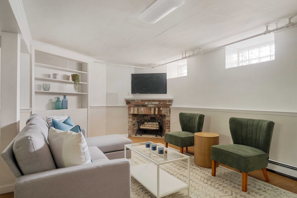 52 St Mary's Road Milton, MA 02186 - Photo 26 of 32 a living room with furniture a fireplace and a flat screen tv