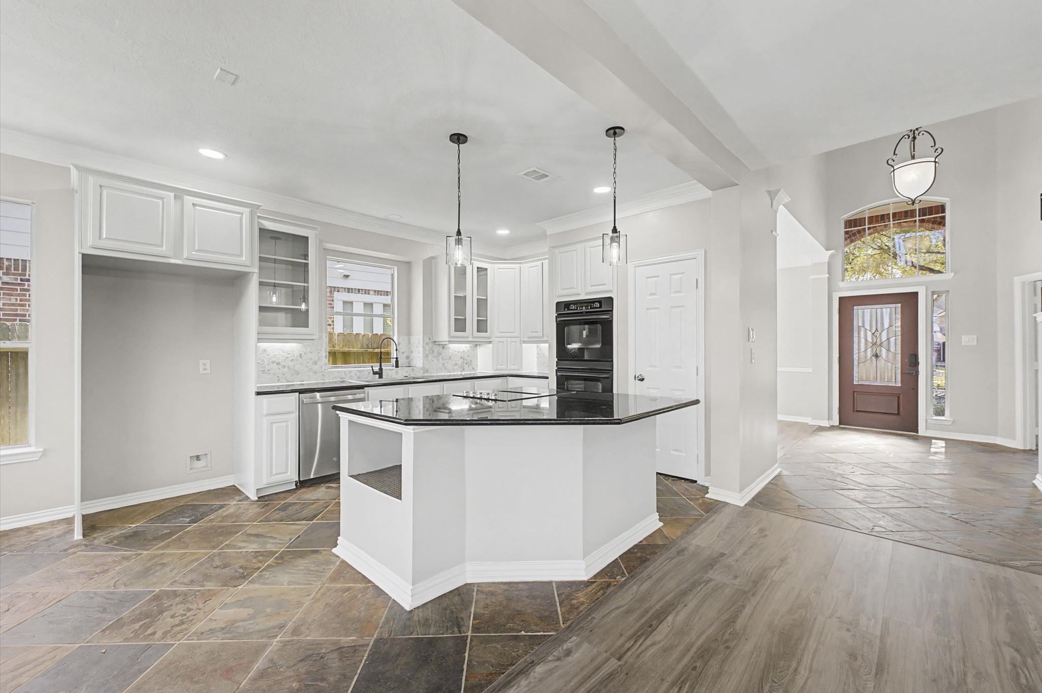 15442 Bay Tree Landing Cypress, TX 77429 - Photo 10 of 46 Wonderfully updated kitchen with a large island, new cooktop, custom trim out in the island & glass pendant lights... all nicely opened up connecting the kitchen with the living area & breakfast room.