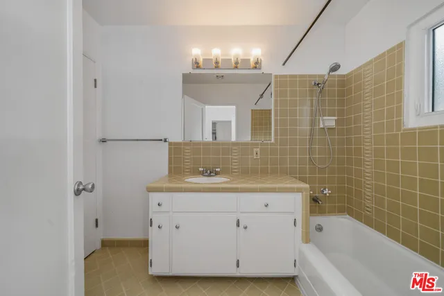 a bathroom with a sink double vanity granite tub shower and mirror