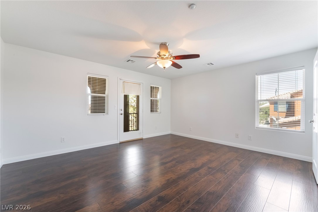 3175 Via Seranova Henderson, NV 89044 - Photo 20 of 45 This airy room features rich hardwood flooring and a ceiling fan, creating a welcoming and comfortable atmosphere.