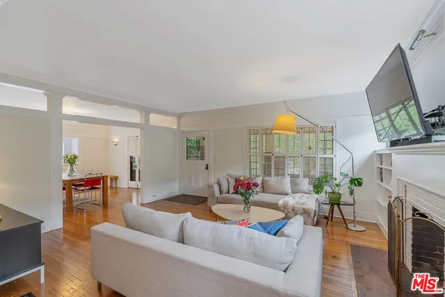 a living room with furniture fireplace and a large window
