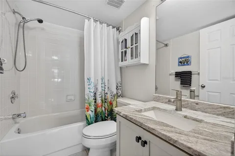 a bathroom with a granite countertop sink a toilet and shower