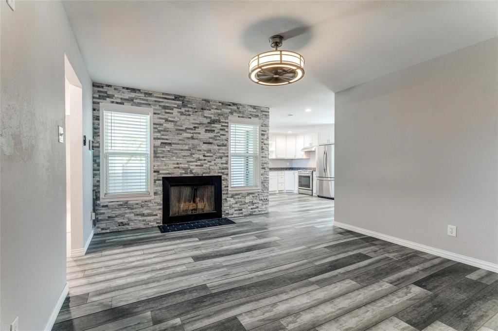 a view of a livingroom with a fireplace and wooden floor