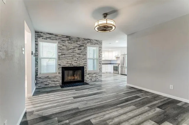 a view of a livingroom with a fireplace and wooden floor