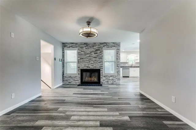 a view of empty room with wooden floor and fireplace