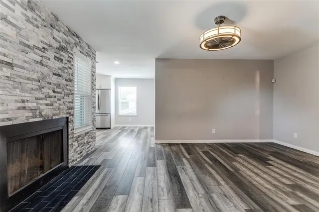 a view of empty room with wooden floor and fireplace