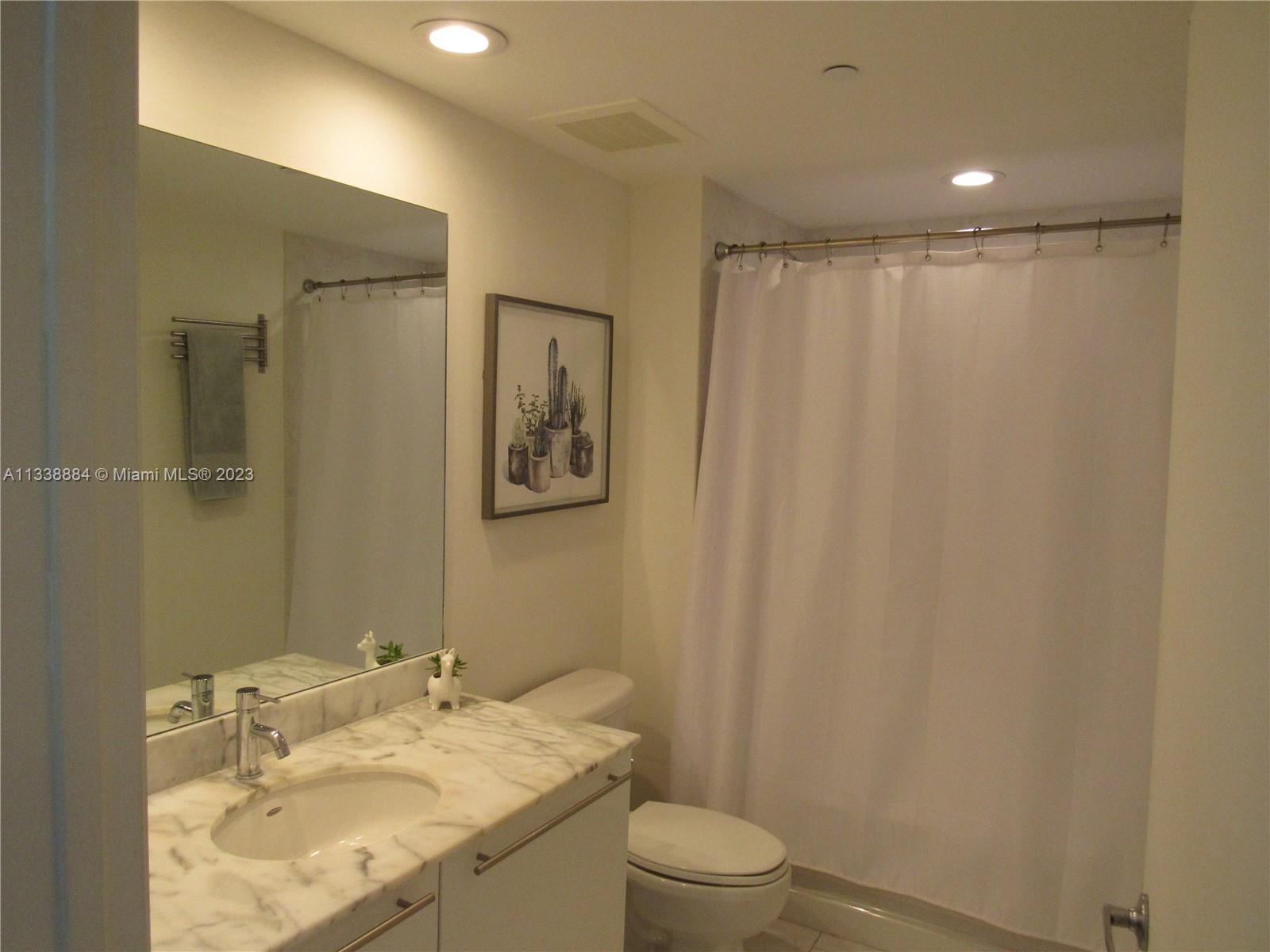 Plaza on Brickell Miami, FL 33131 - Photo 11 of 31 a bathroom with a granite countertop sink toilet and a mirror
