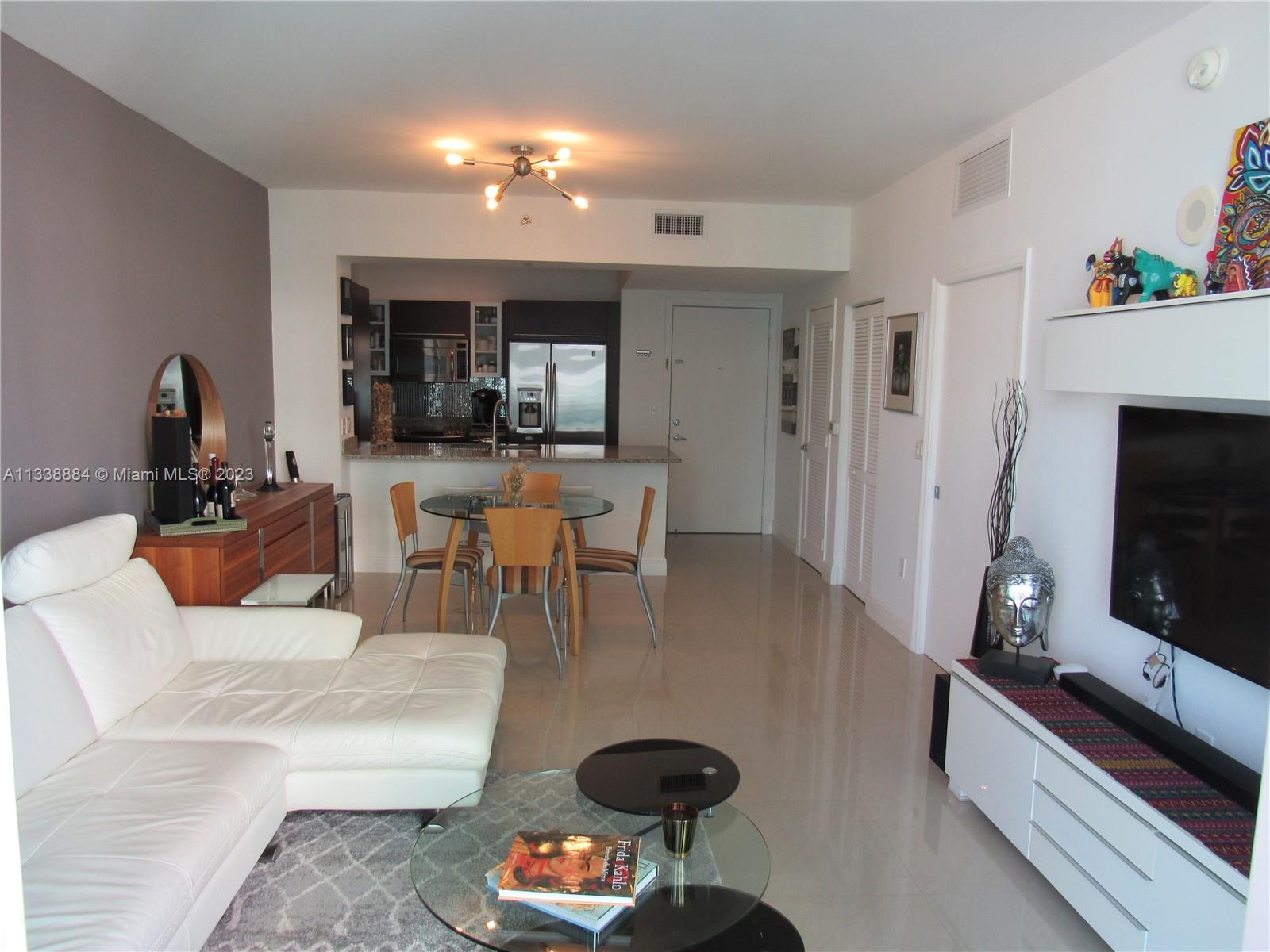 Plaza on Brickell Miami, FL 33131 - Photo 4 of 31 a living room with furniture a flat screen tv and a fireplace