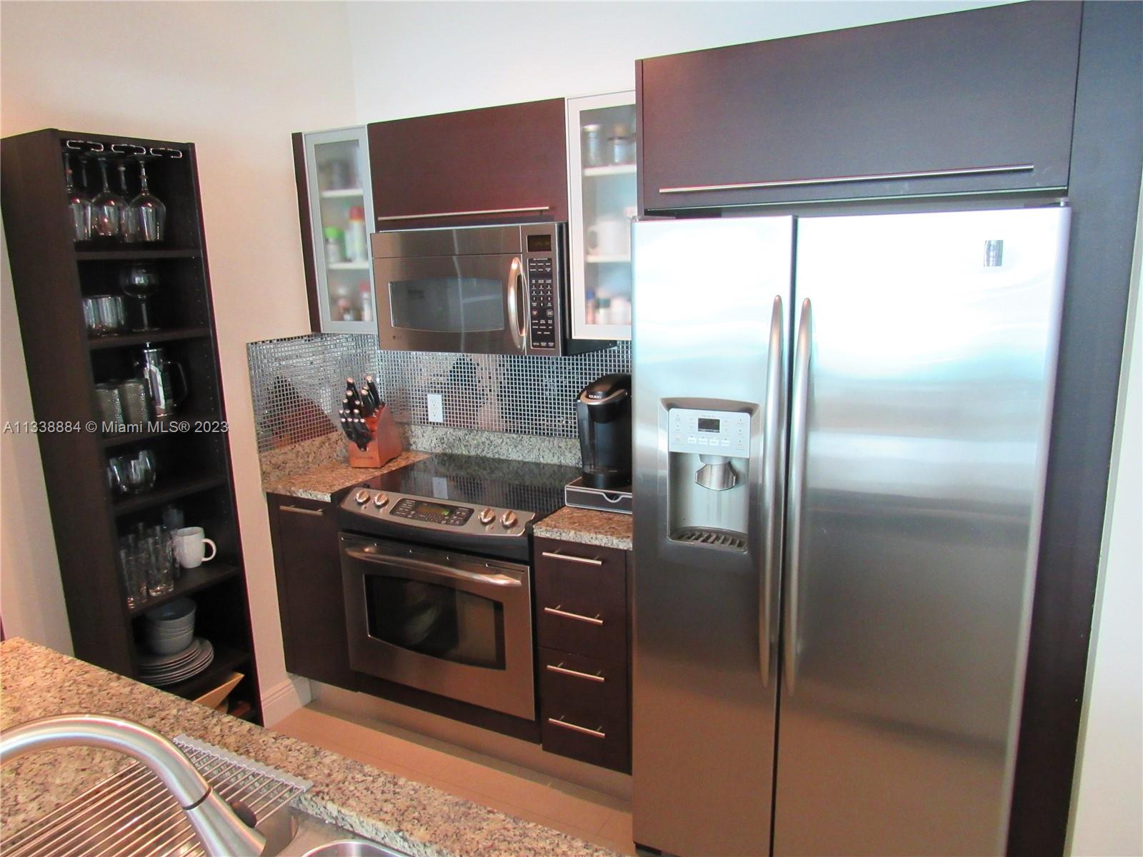 Plaza on Brickell Miami, FL 33131 - Photo 7 of 31 a kitchen with stainless steel appliances granite countertop a refrigerator a stove and a refrigerator with wooden floor