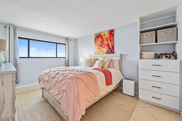 a bedroom with a bed and a flat tv screen on the dresser