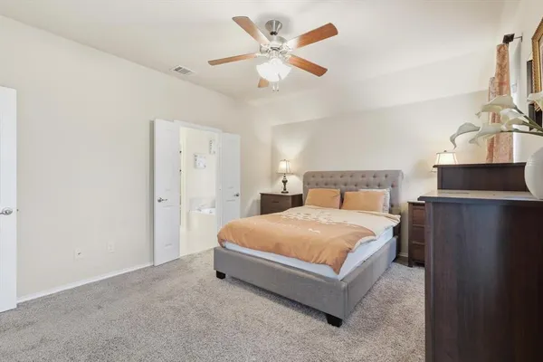 a bedroom with a bed and a ceiling fan