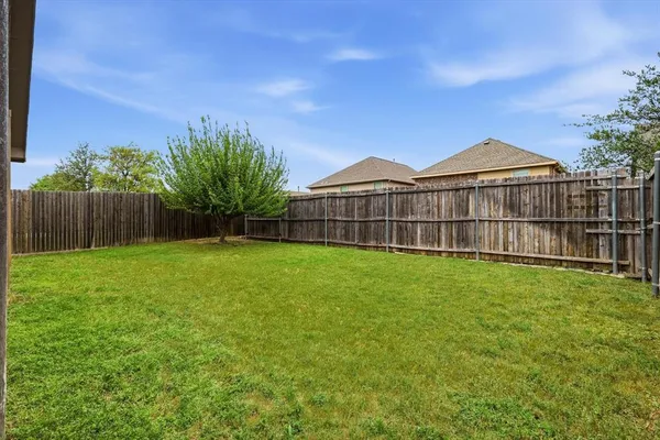 a view of a backyard with a small cabin and wooden fence