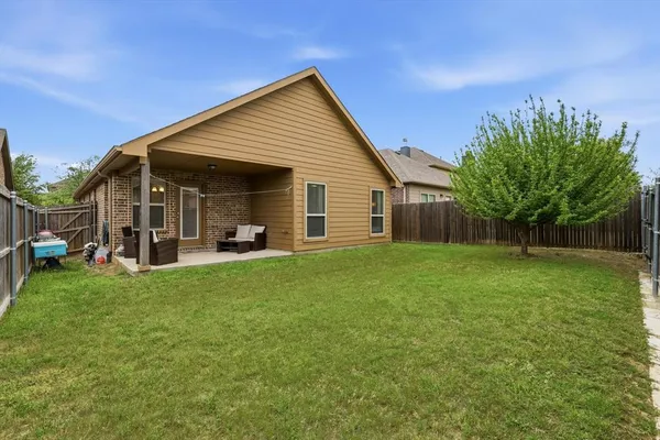 a view of a house with backyard and sitting area