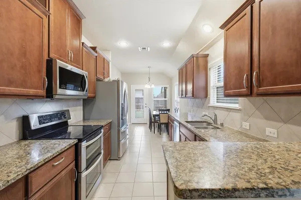 a kitchen with stainless steel appliances granite countertop a sink stove and microwave