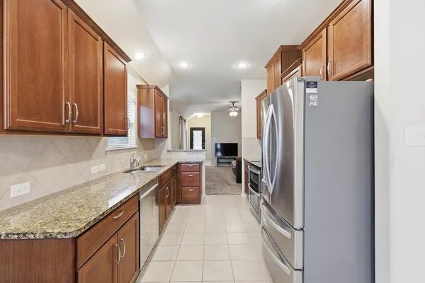 a kitchen with granite countertop a refrigerator and a sink