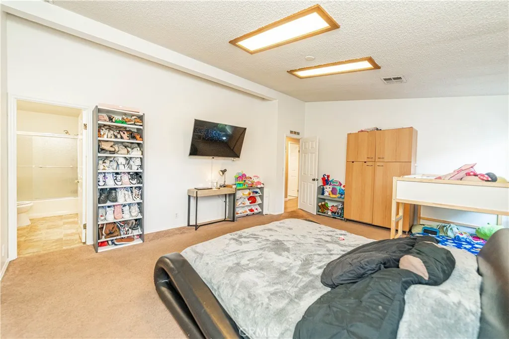 9080 Bloomfield Avenue, Unit 191 Cypress, CA 90630 - Photo 9 of 22 a bedroom with a bed and a flat screen tv