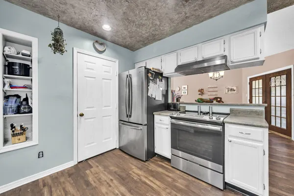 a kitchen with stainless steel appliances granite countertop a refrigerator and a stove top oven