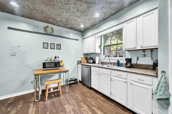 a kitchen with granite countertop cabinets a sink and appliances