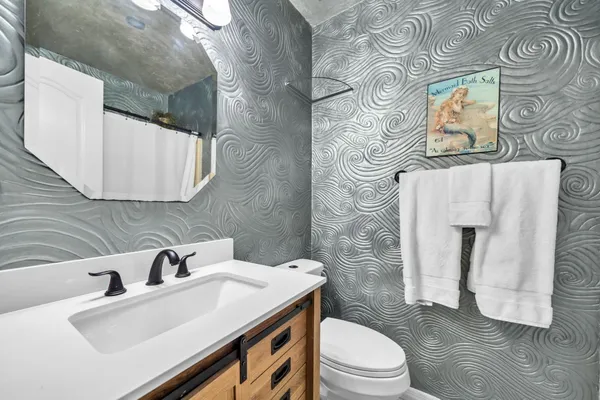 a bathroom with a sink a toilet and mirror