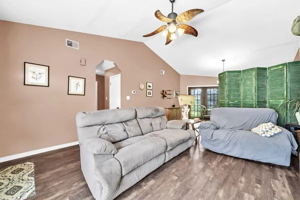 a living room with furniture ceiling fan and a rug