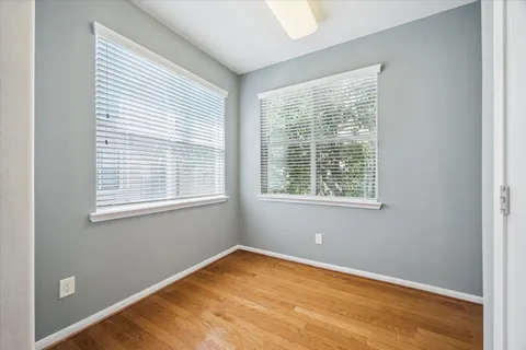 an empty room with windows and fan