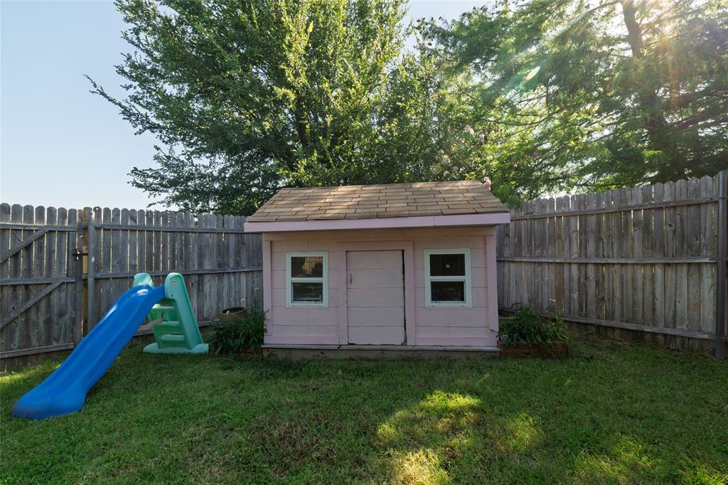 4025 Chisos Rim Trail Fort Worth, TX 76244 - Photo 34 of 40 Fenced backyard with a wooden playhouse featuring a shingled roof and two windows