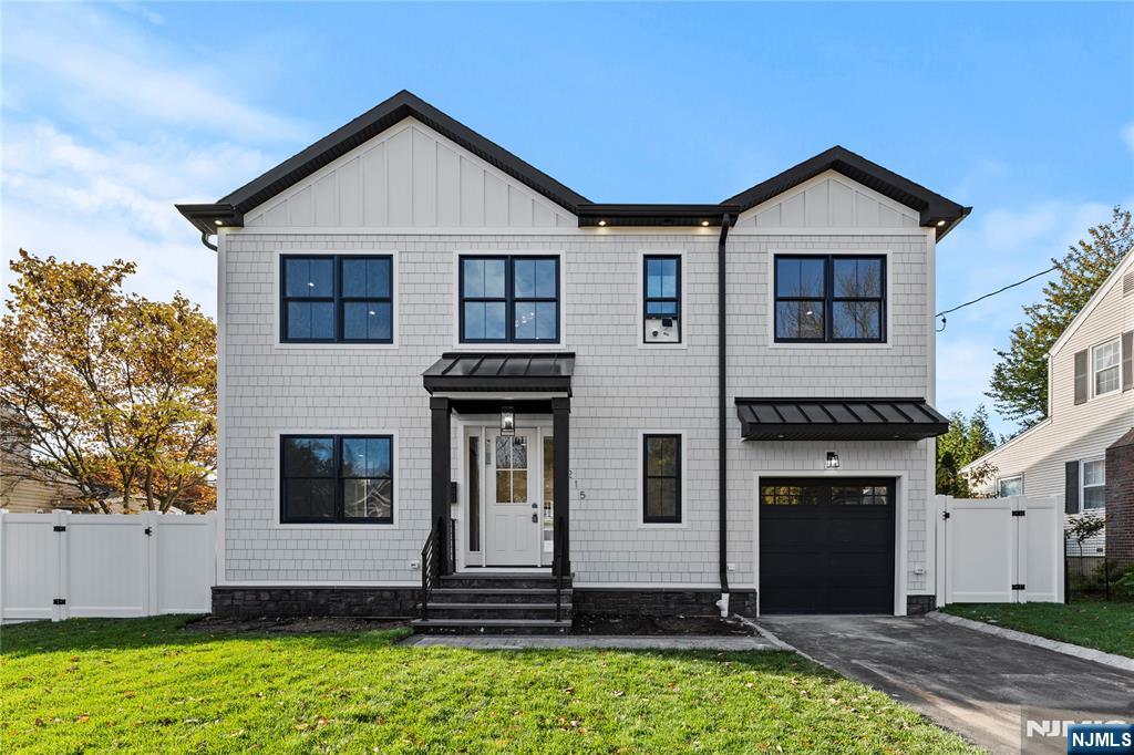 a view of a house with yard and large tree