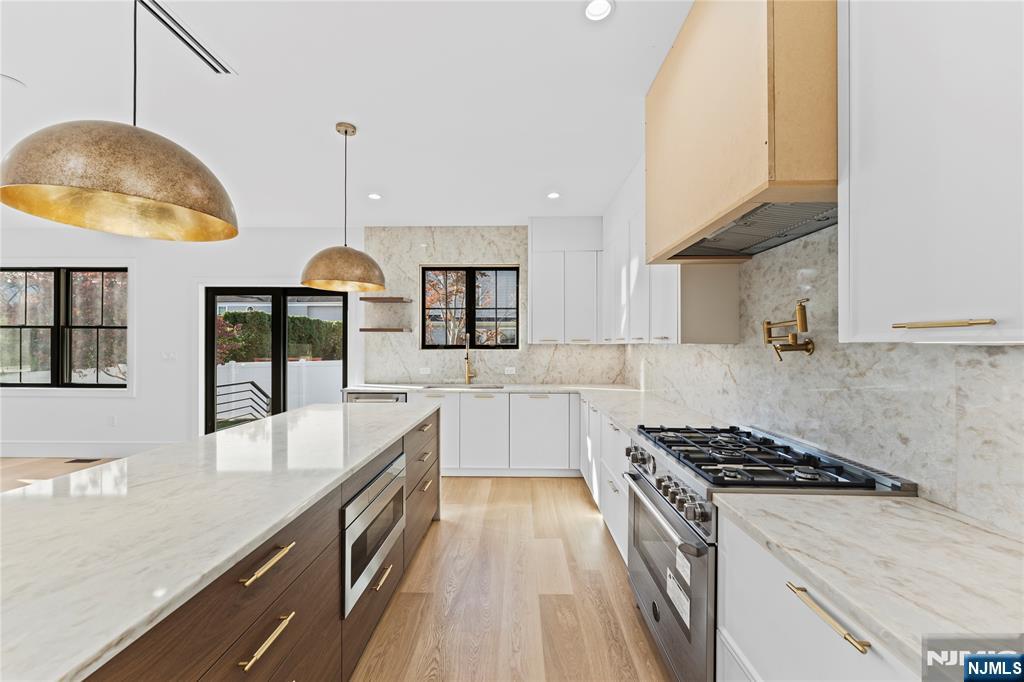 215 Kensington Road River Edge, NJ 07661 - Photo 8 of 37 a kitchen with granite countertop a stove a sink a counter space and cabinets