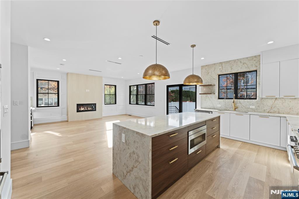 215 Kensington Road River Edge, NJ 07661 - Photo 9 of 37 a kitchen with stainless steel appliances granite countertop a sink a stove top oven a counter space and cabinets