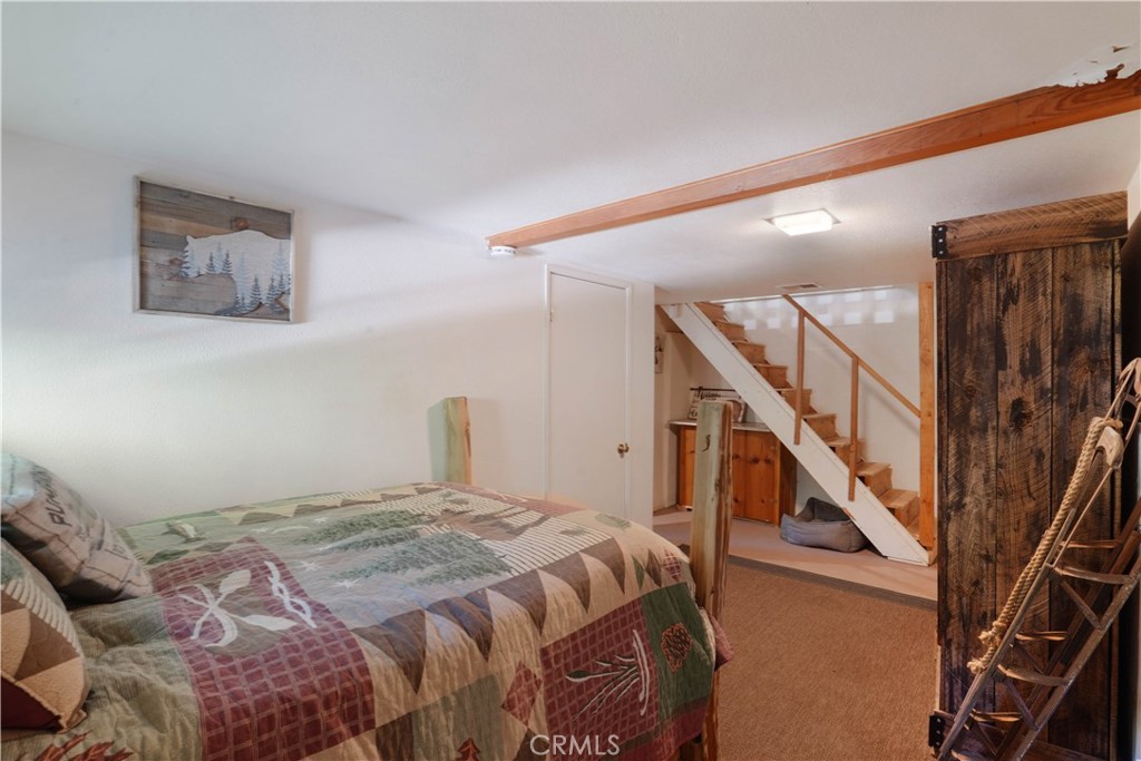 825 Cottage Grove Road Lake Arrowhead, CA 92352 - Photo 20 of 25 a bedroom with a bed and stairs