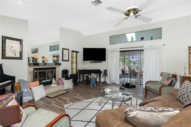 a living room with furniture and a flat screen tv with kitchen view