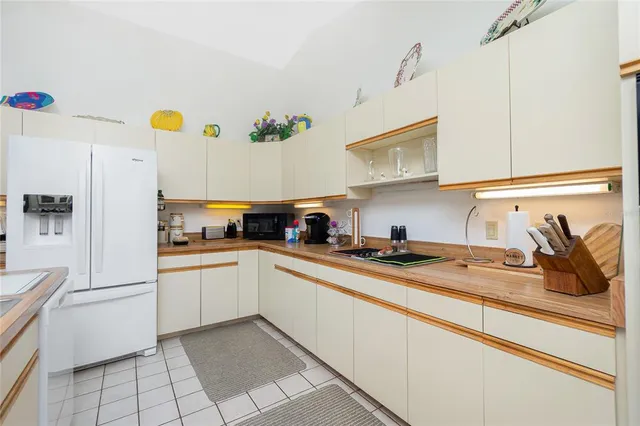 a kitchen with stainless steel appliances granite countertop a sink and a refrigerator