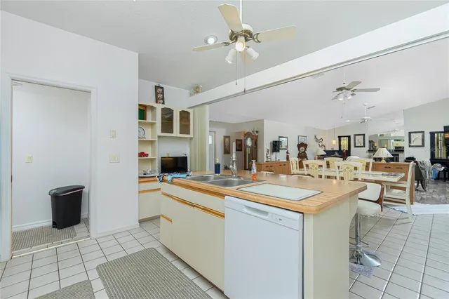 a room with stainless steel appliances kitchen island granite countertop a sink and cabinets