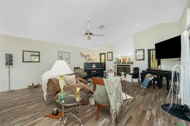 a living room with furniture a dining table and a flat screen tv with kitchen view