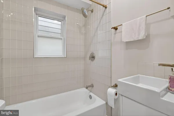 a white bath tub sitting next to a white sink and vanity