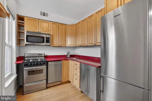 a kitchen with stainless steel appliances a stove microwave and a refrigerator