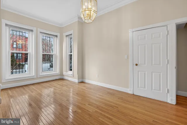 a view of an empty room with wooden floor