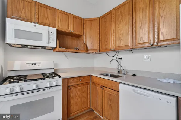 a kitchen with stainless steel appliances granite countertop a sink a stove and cabinets