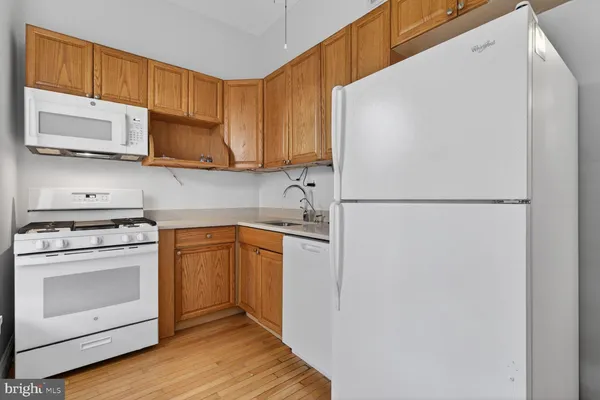 a kitchen with stainless steel appliances white cabinets and a refrigerator