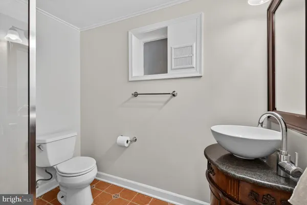 a bathroom with a toilet a sink and mirror