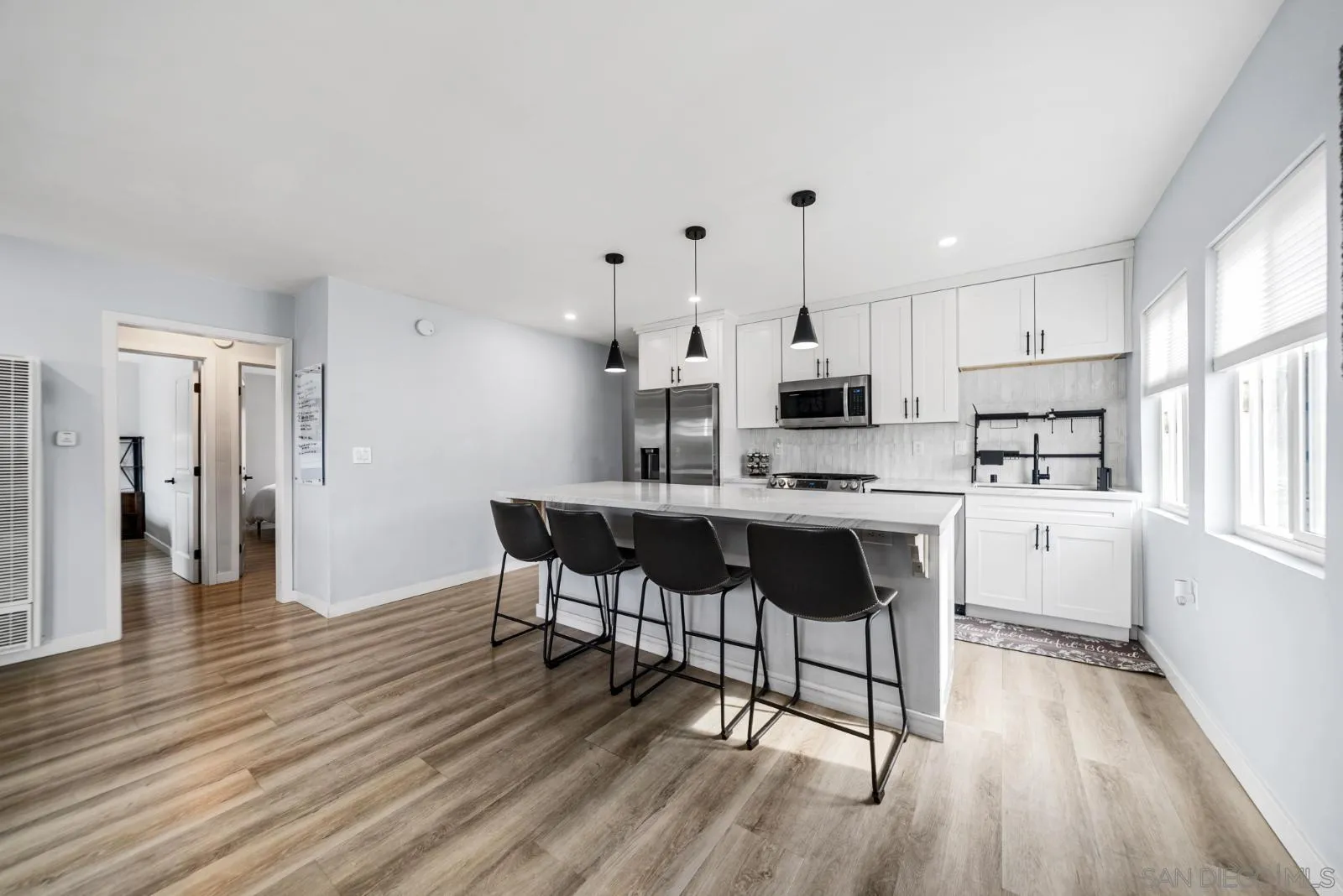 a kitchen with stainless steel appliances a dining table chairs stove a refrigerator and cabinets