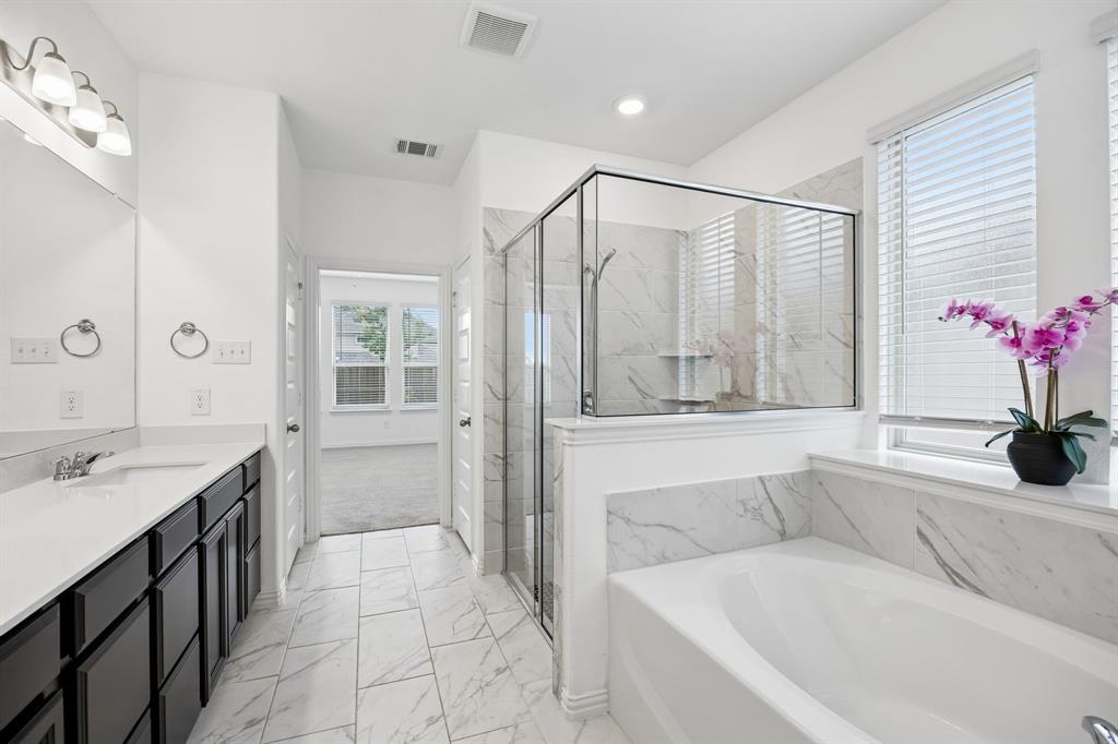 1303 Wheelwright Drive Forney, TX 75126 - Photo 9 of 39 Bathroom featuring a double vanity with dark cabinetry, integrated sinks, and chrome fixtures