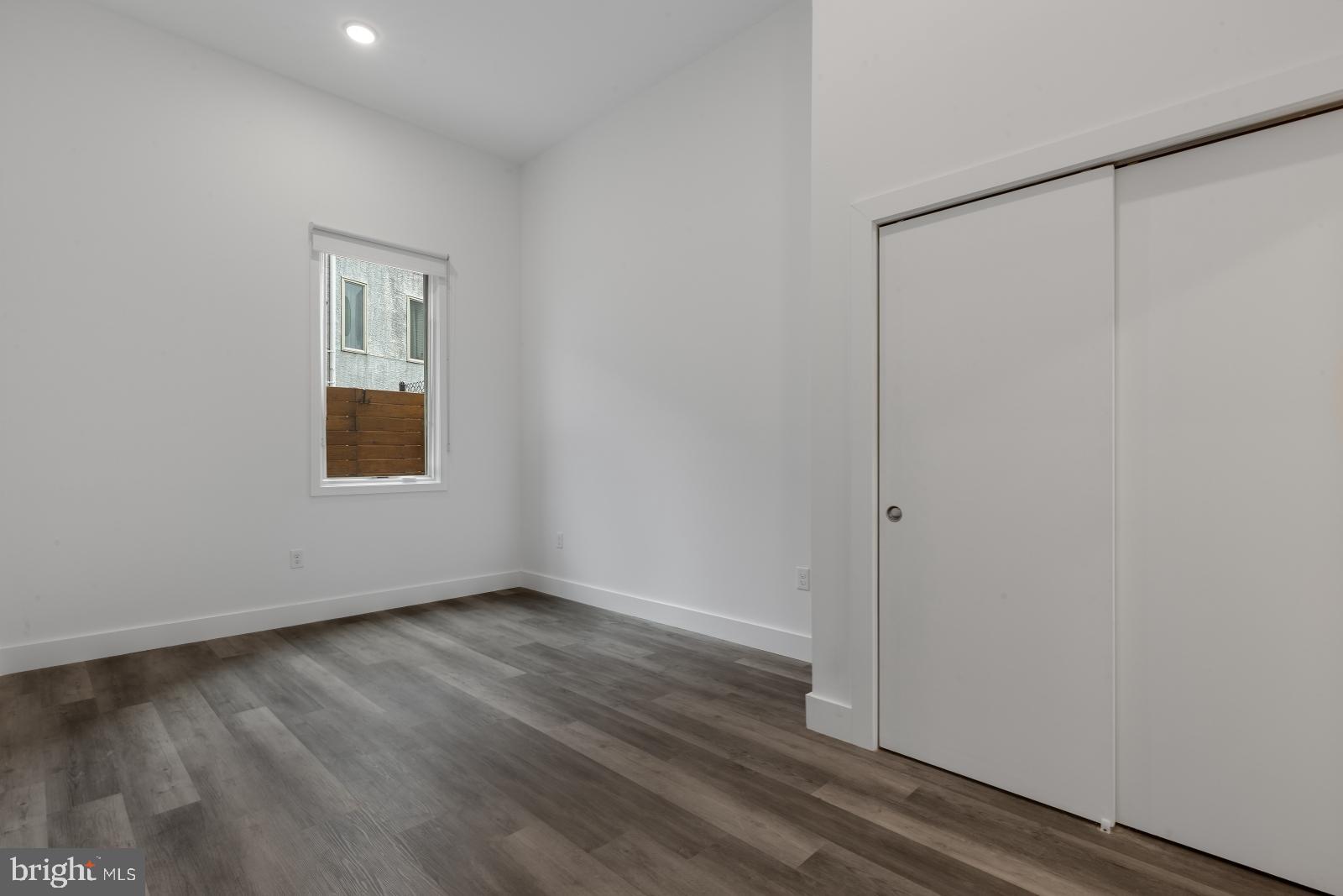 2559 Amber Street, Unit 101 Philadelphia, PA 19125 - Photo 16 of 35 a view of an empty room with wooden floor and a window