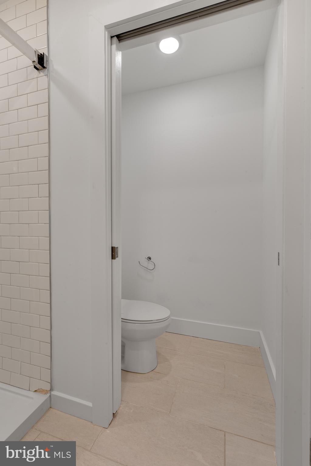 2559 Amber Street, Unit 101 Philadelphia, PA 19125 - Photo 25 of 35 a bathroom with a granite countertop toilet and a shower