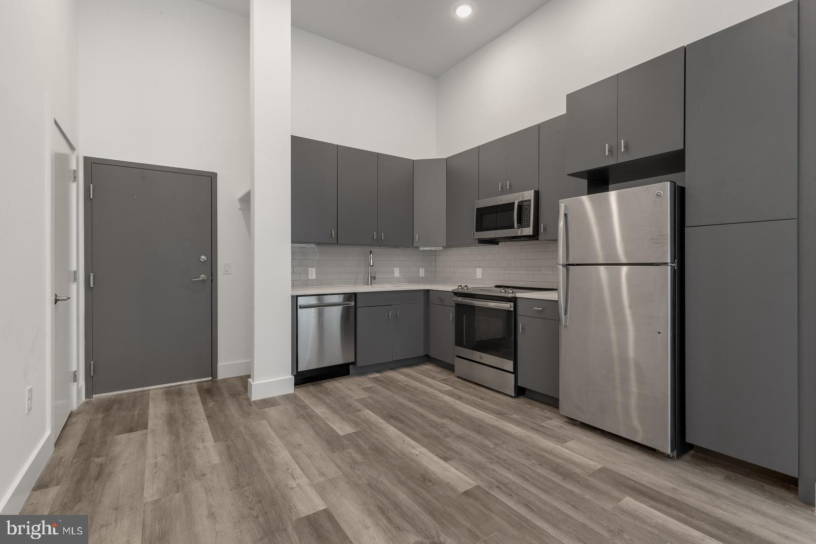 2559 Amber Street, Unit 101 Philadelphia, PA 19125 - Photo 3 of 35 a kitchen with a refrigerator a stove top oven a sink and dishwasher
