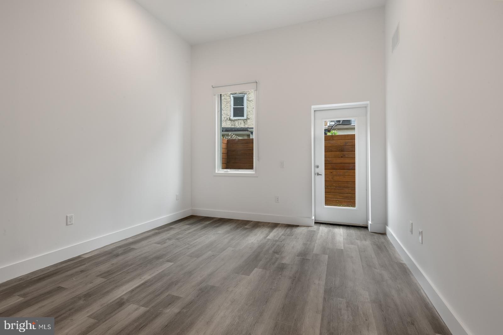 2559 Amber Street, Unit 101 Philadelphia, PA 19125 - Photo 4 of 35 an empty room with wooden floor and windows