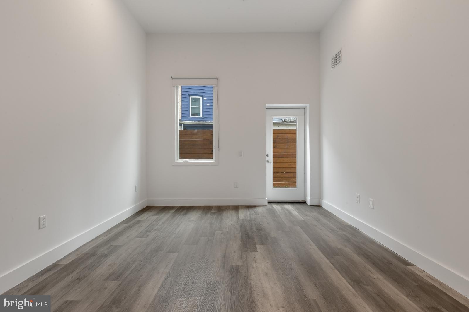 2559 Amber Street, Unit 101 Philadelphia, PA 19125 - Photo 7 of 35 a view of an empty room with wooden floor and a window