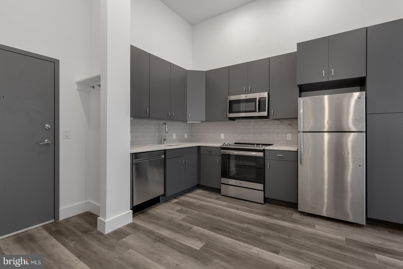2559 Amber Street, Unit 101 Philadelphia, PA 19125 - Photo 10 of 35 a kitchen with a refrigerator and a stove top oven