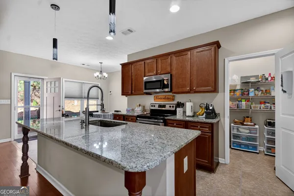 a kitchen with granite countertop a sink counter top space appliances and cabinets