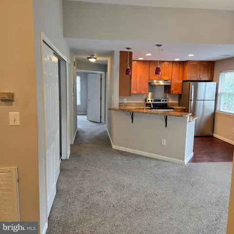 a view of a kitchen with kitchen island a sink a stove and wooden floor